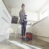 One woman mopping the floor in her kitchen.